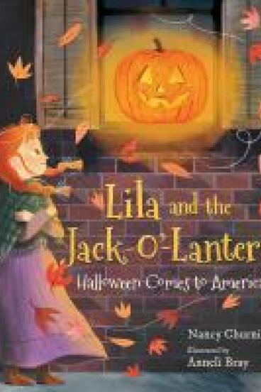 book cover for Lila and the Jack-o'-Lantern, featuring an illustration of a redheaded girl standing outside and smiling serenely at a Jack-o'-Lantern perched in a window sill with shutters open.  Autumn leaves and the girl's hair and clothes blow in the wind, and light glows out from the Jack-o'-Lantern.