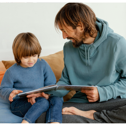 A father and son read together.