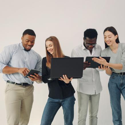 A young group of diverse people working together and using laptop computers.