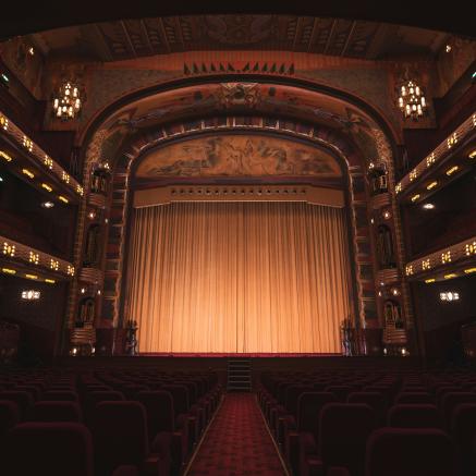 Facing the stage of a theater while the curtain is down.