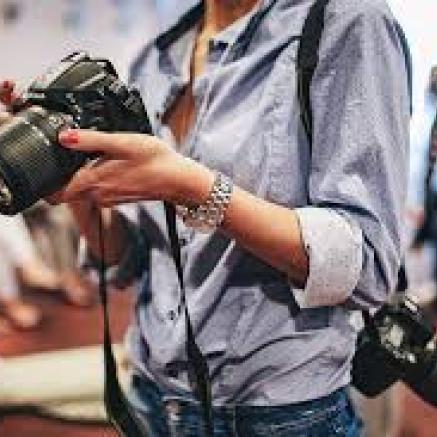 Picture of photographer's body with camera's hanging off of her. 