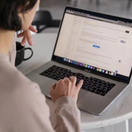 A person searching on a laptop computer.