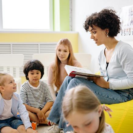 A teacher reads to a group of children.