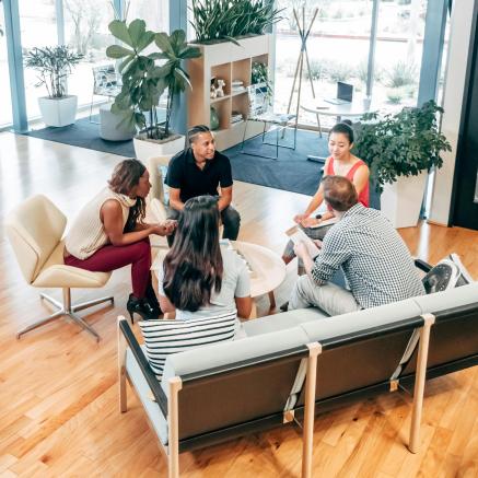 A group of people sitting around a table having a conversation.