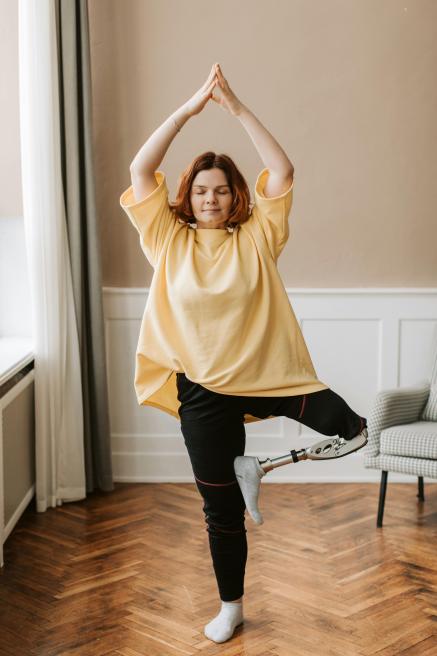 A woman with a prosthetic leg strikes an exercise pose.