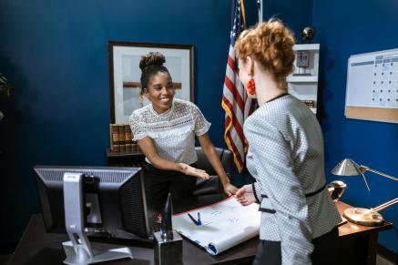 Women shake hands over a desk