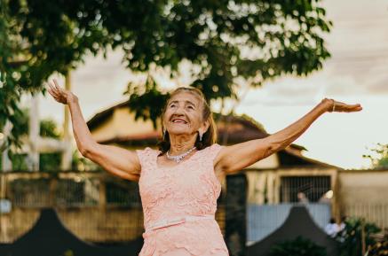 Senior woman with her arms in the air, dancing