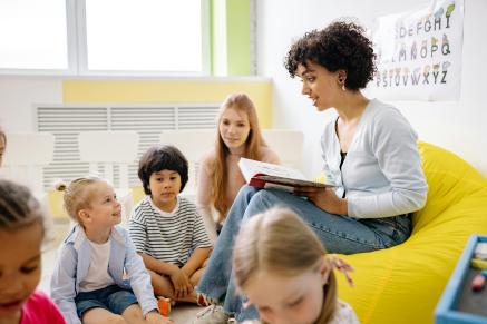 A teacher reads to a group of children.