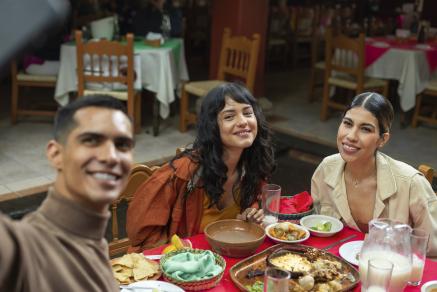 Three adults enjoying Mexican food and taking a selfie.