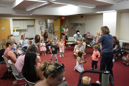 Music & Movement at Cinnaminson Library - kids dance and play instruments in the middle of a circle of parents