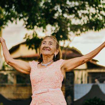 Senior woman with her arms in the air, dancing